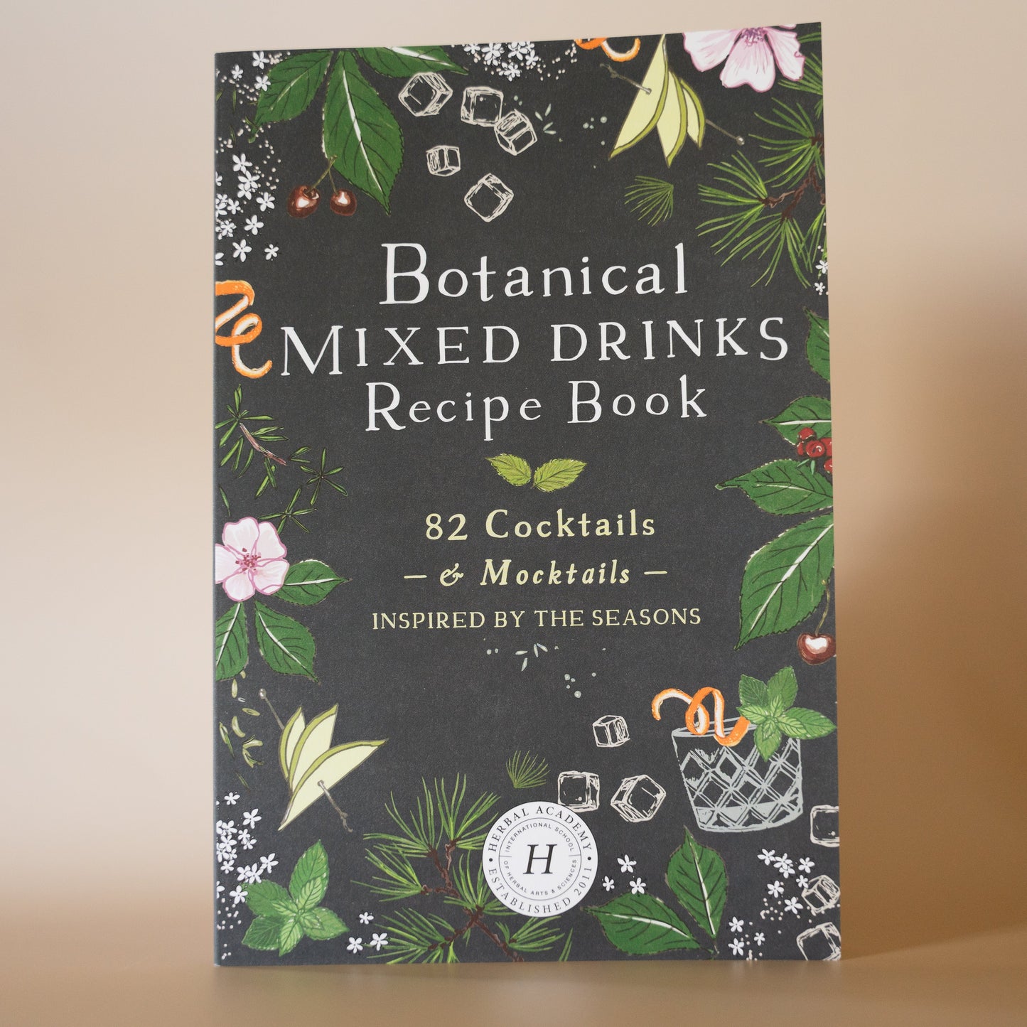 A book cover of 'Botanical Mixed Drinks Recipe Book' by Herbal Academy, featuring a floral and botanical design.