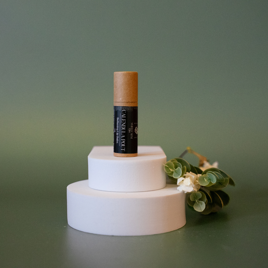 Skincare product with cork lid on a white stand against a green background