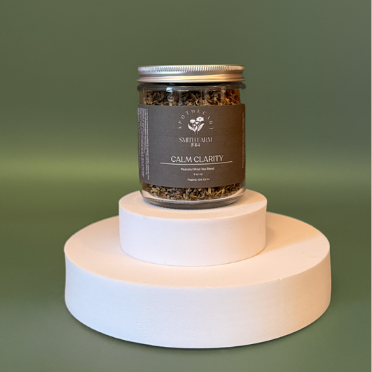 Jar of 'Calm Clarity' tea on a white pedestal with a green background