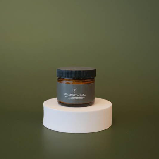 Jar of 'Healing Tallow' on a white pedestal against a green background