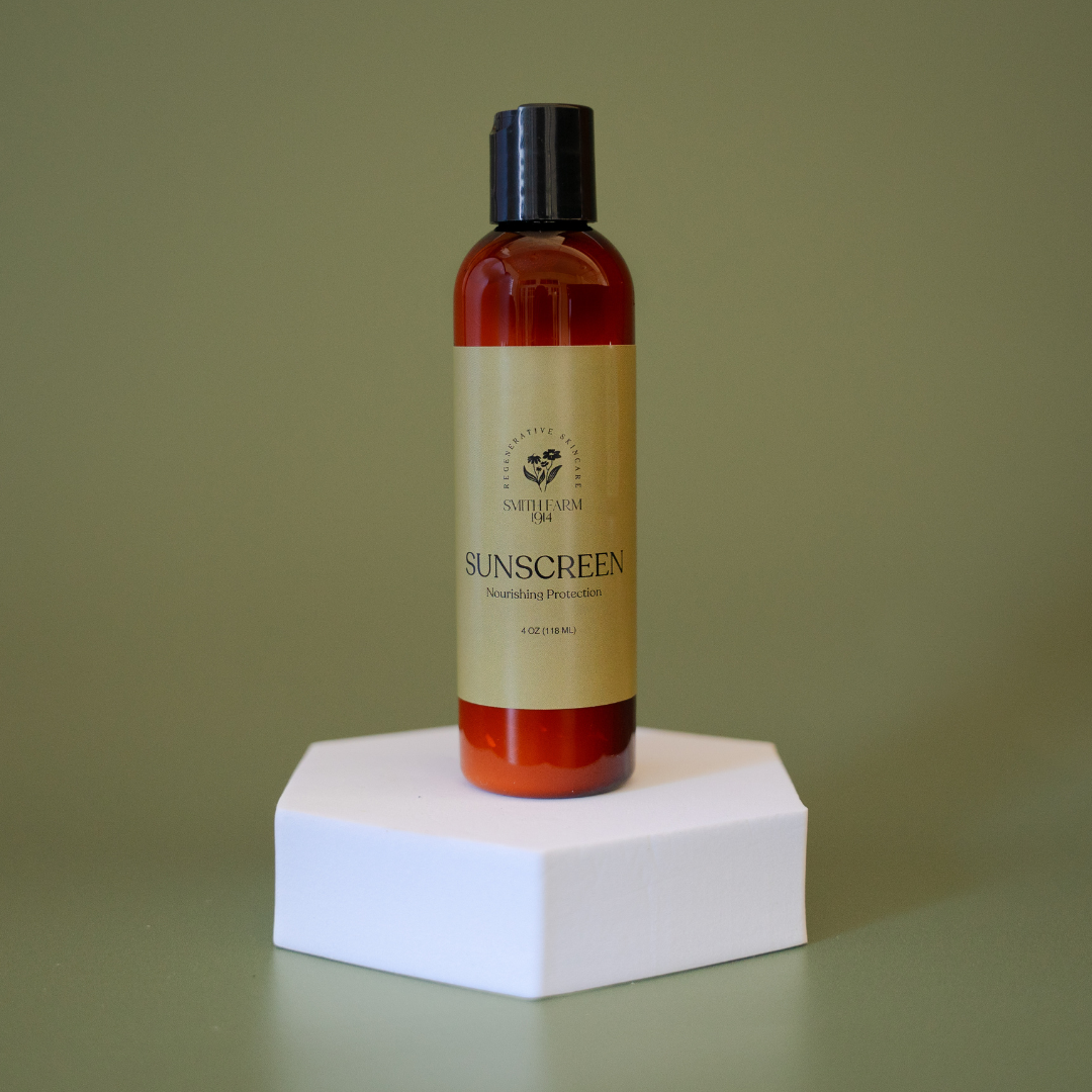 Sunscreen bottle on a white hexagonal platform with a green background