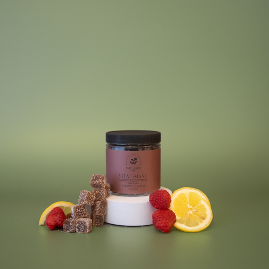 Jar of gummies with lemon slices and raspberries on a green background